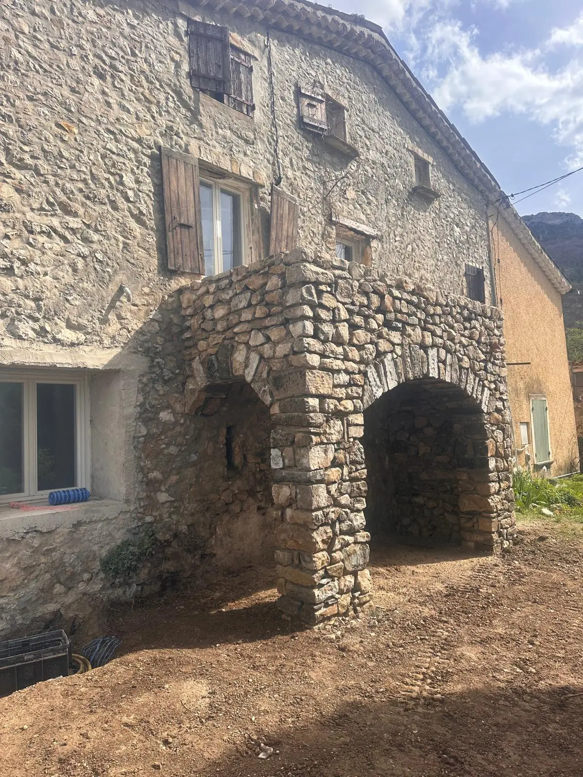 Deux arcs en pierre terminés au pied de la façade