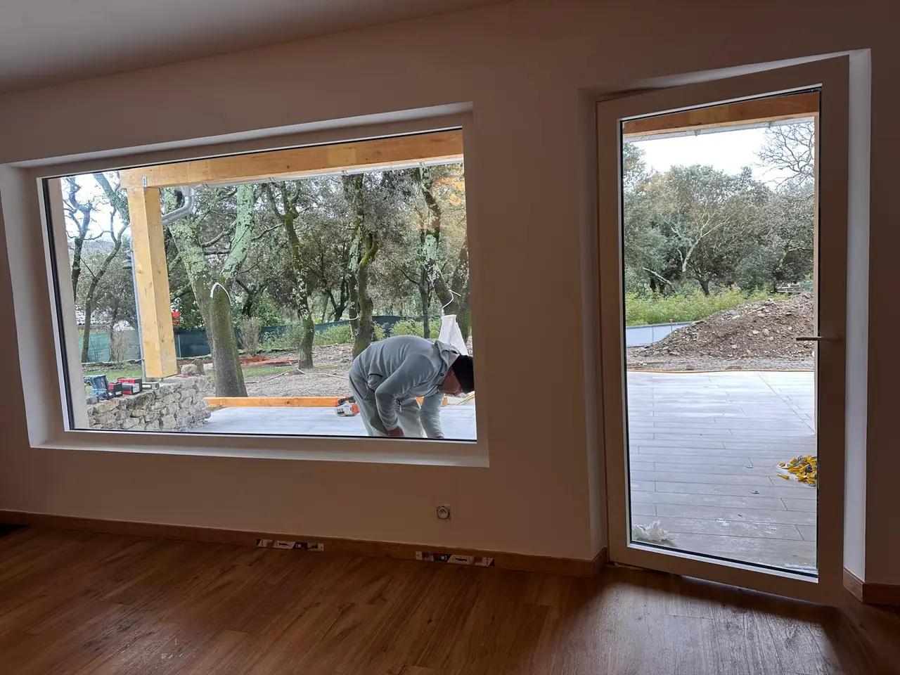 Vu de l’intérieur : grande baie et porte-fenêtre ouvertes sur une terrasse