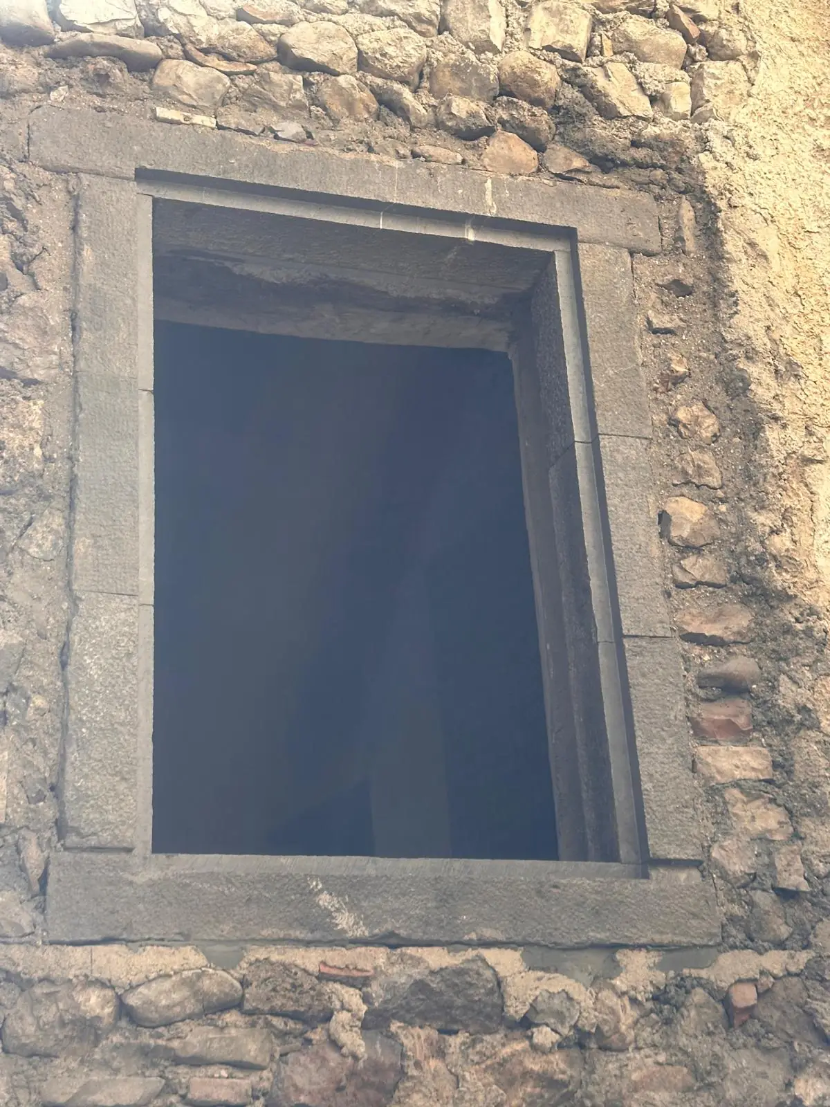 Fenêtre et son encadrement en pierre de taille, dans un mur en moellons