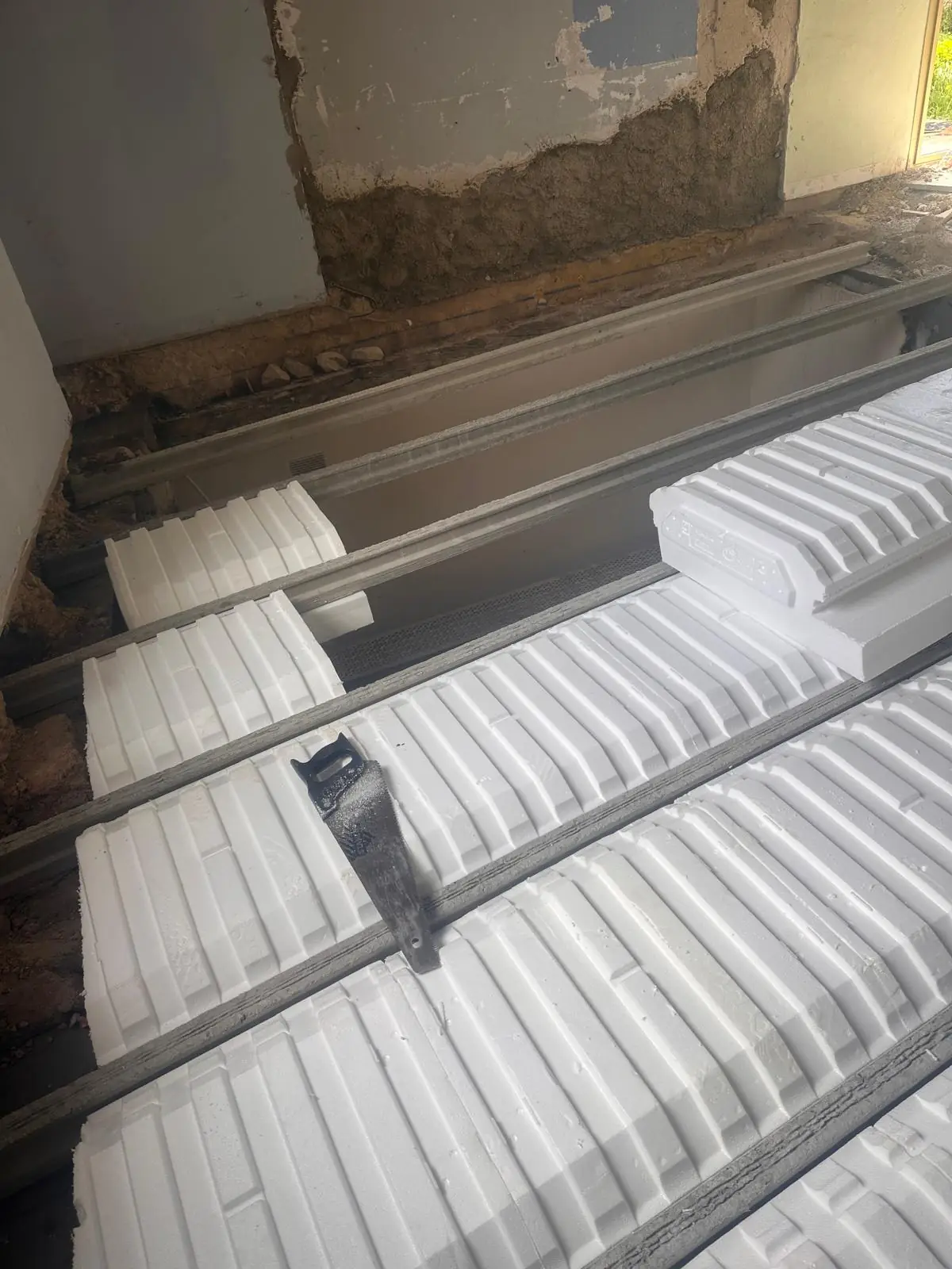 Entrevous isolants posés entre les poutrelles d’un plancher, le long d’un mur