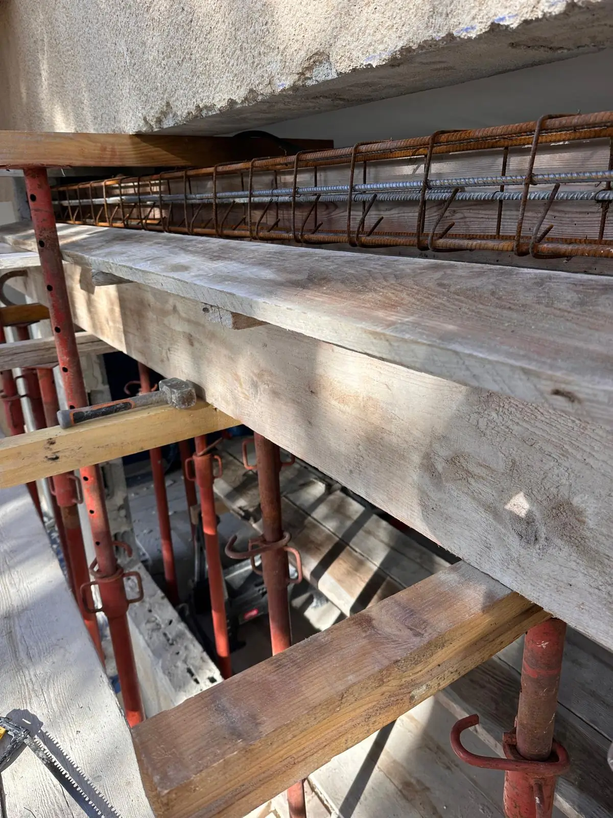 Ferraillage d’un linteau en béton dans son coffrage, soutenu par des étais