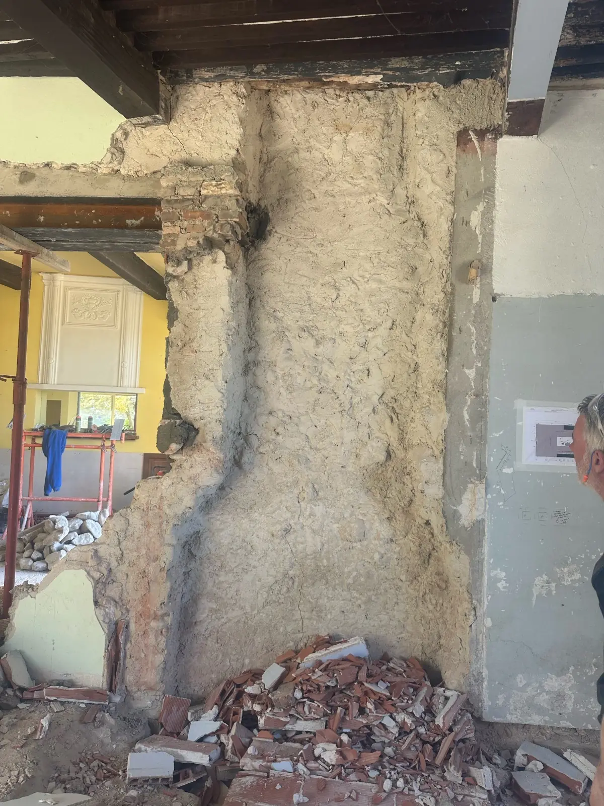 Mur intérieur décroûté jusqu’à la maçonnerie, gravats au sol