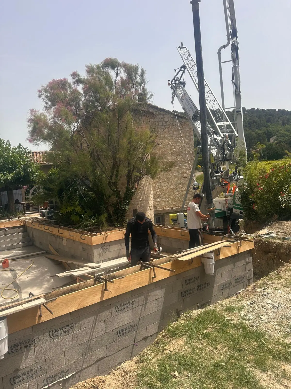Murs d’une piscine en blocs à bancher remplis à la pompe à béton