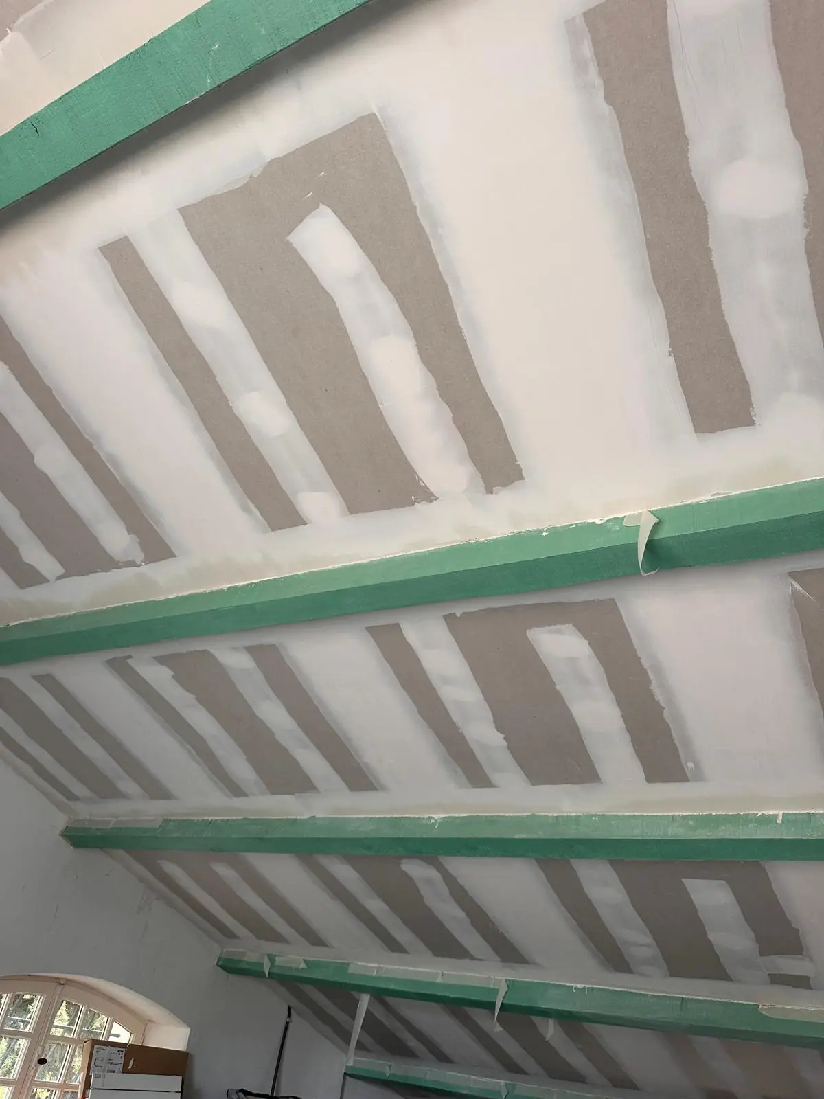 Plafond en plaques de plâtre entre des solives peintes, bandes enduites