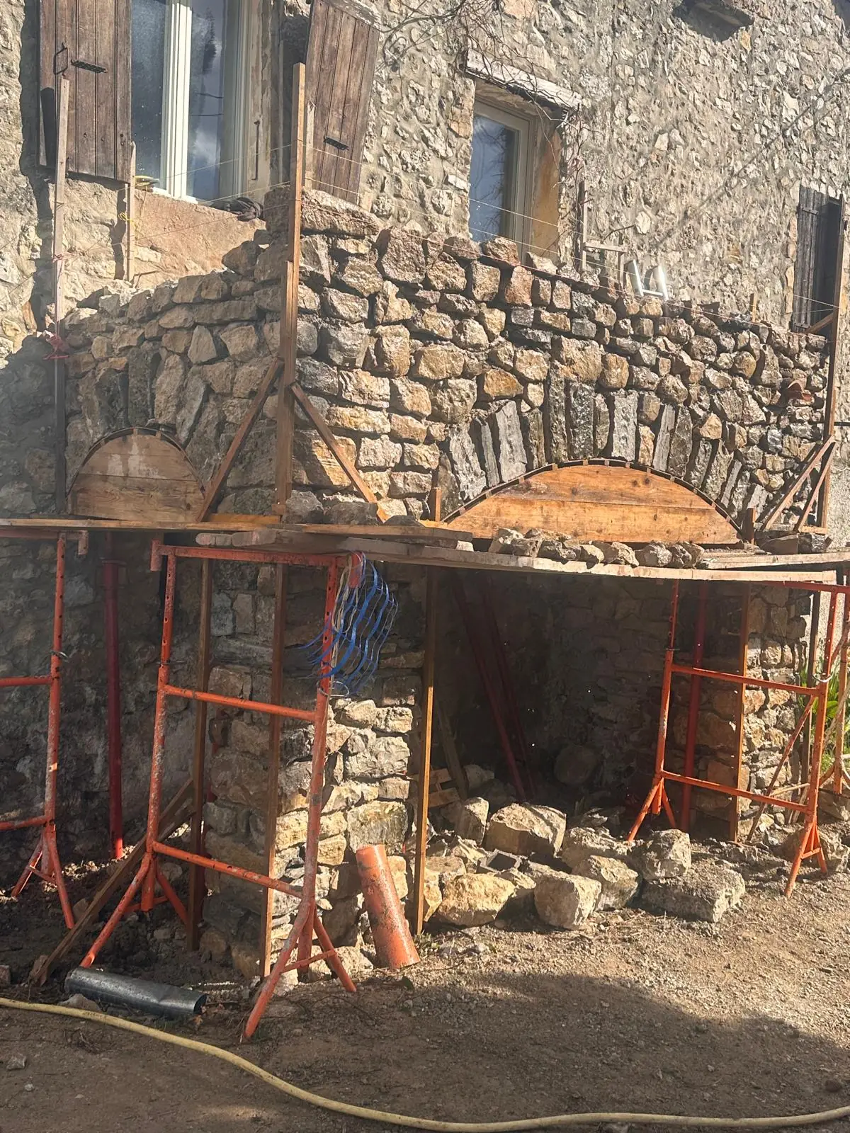 La même façade : piliers en pierre montés, arcs maçonnés sur leurs cintres en bois