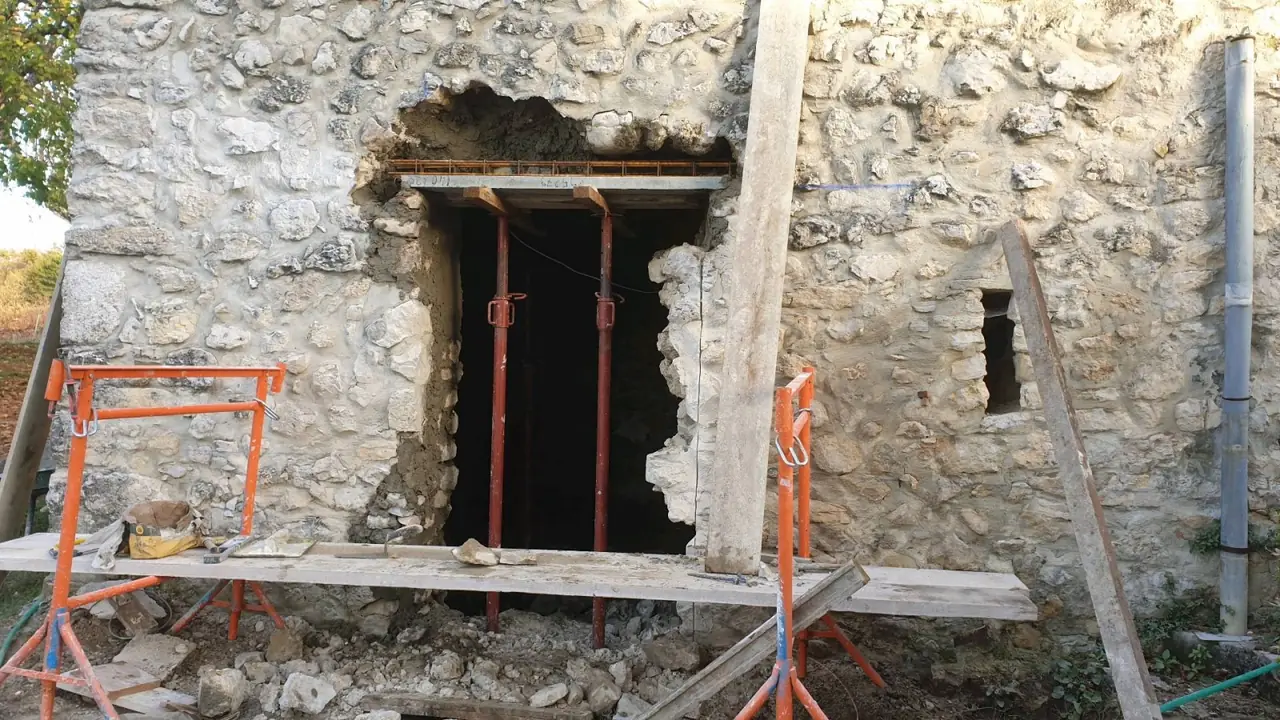 Mur en pierre en cours d’ouverture : linteau provisoire, étais métalliques et tréteaux